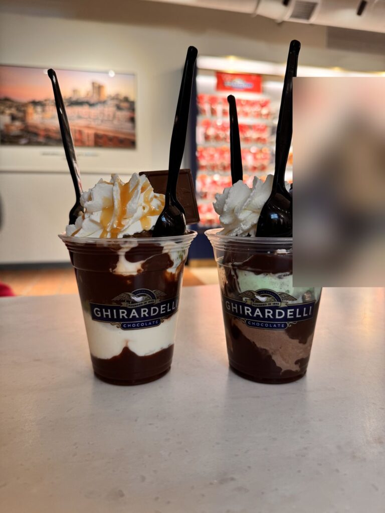 Two hot fudge sundaes with whipped cream and chocolate squares at Ghirardelli