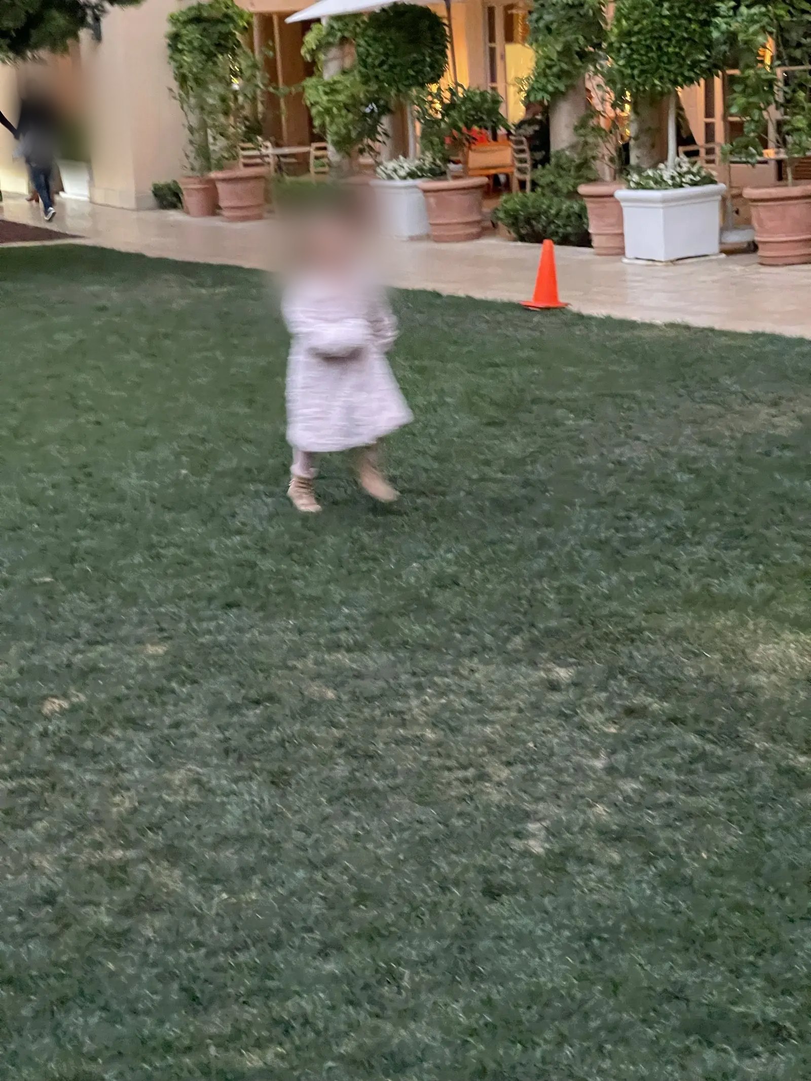 Charlotte running and laughing across the lawn during a game of hide-and-seek at The Terrace at The Maybourne before dinner
