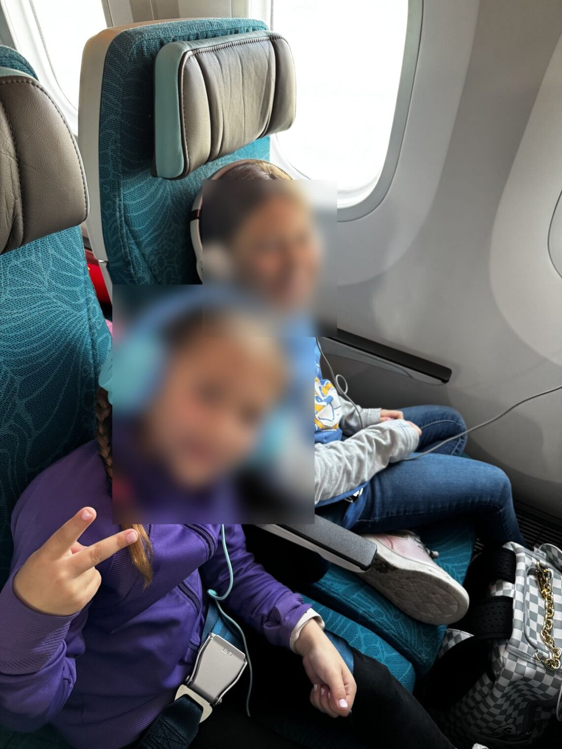 Two kids in Hawaiian Airlines economy seats on the 787