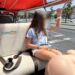 Girl riding in a red-roofed tuk tuk on a Lisbon tuk tuk tour