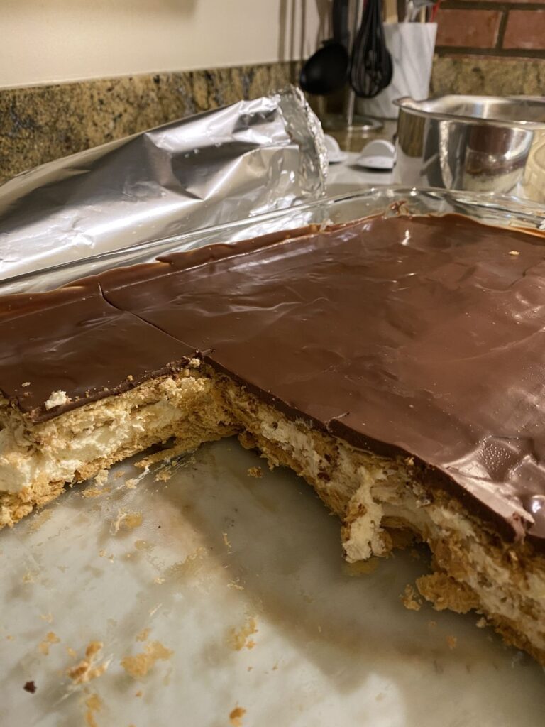Chocolate-topped icebox eclair cake in a glass baking dish