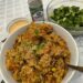 A big bowl of kimchi fried rice with a bowl of smashed cucumbers and spicy mayo