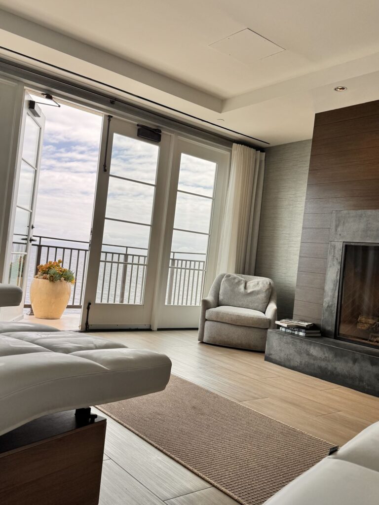 Fireplace and armchair in the Terranea spa relaxation lounge, with the Pacific beyond the balcony