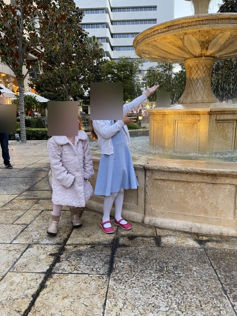 Our two daughters posing by the fountain near The Terrace, faces blurred